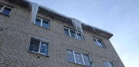 Огромные сосульки висят на крышах домов по улице Коммунаров