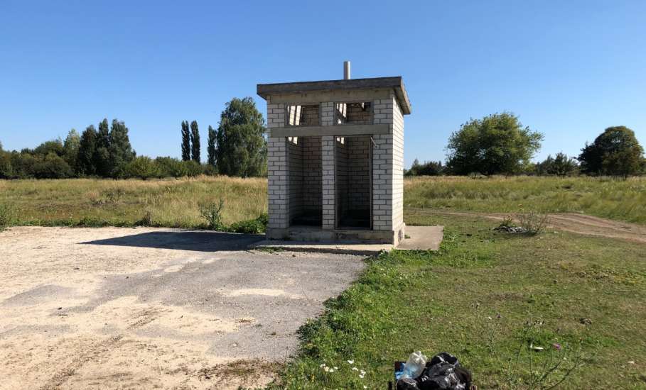 Туалеты без дверей и большое количество флагов на городском кладбище Ельца