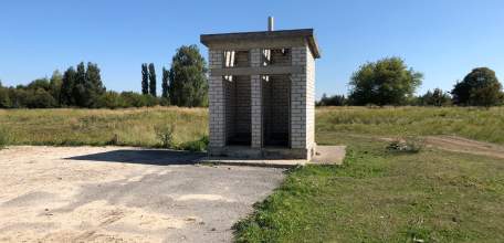 Туалеты без дверей и большое количество флагов на городском кладбище Ельца